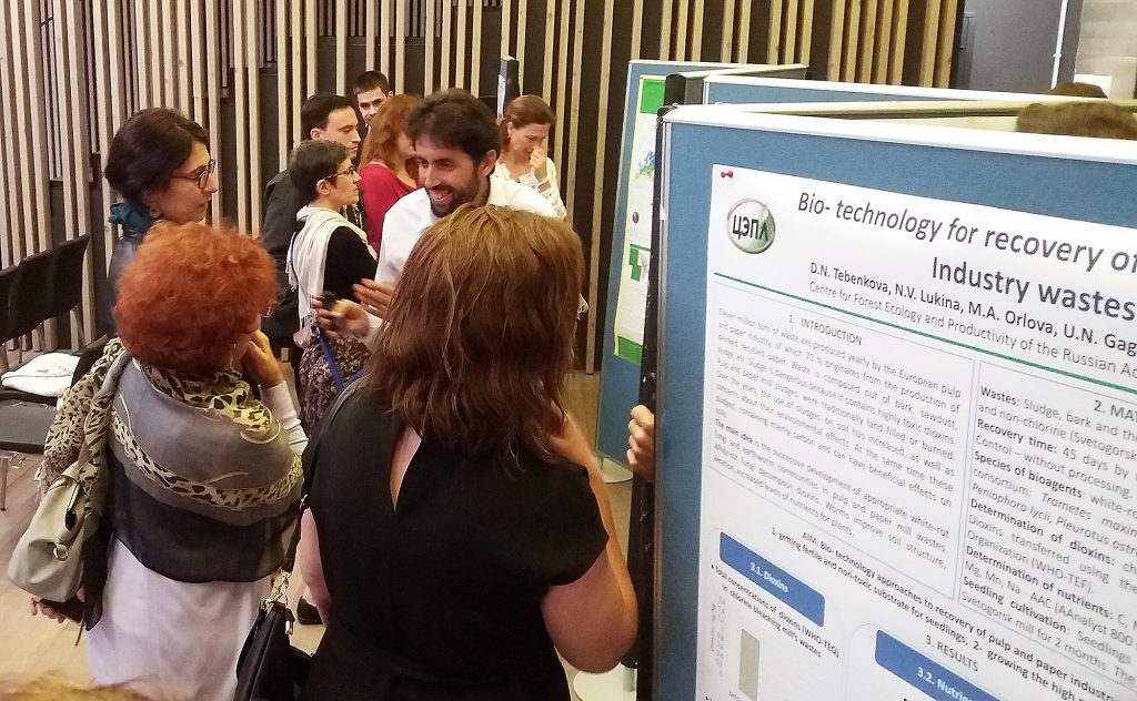 Group of people standing next to posterboards. Photo.