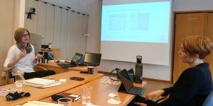 Two women at a conference table. Photo.