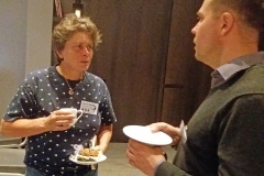 Woman and a man talking while holding coffee mugs. Photo.