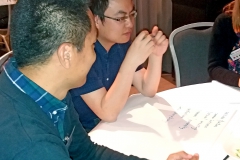 Two men sitting at table. Photo.