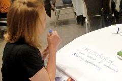 Woman at a table, seen from the back. Photo.