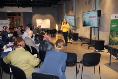 Audience (seen from the back) listens to presentation. Photo.