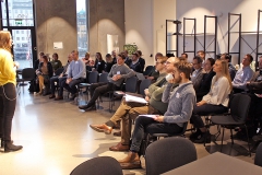 Audience (seen from the side) listens to presentation. Photo.
