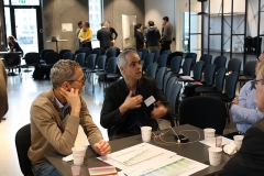 Two men sitting at a black table. Photo.